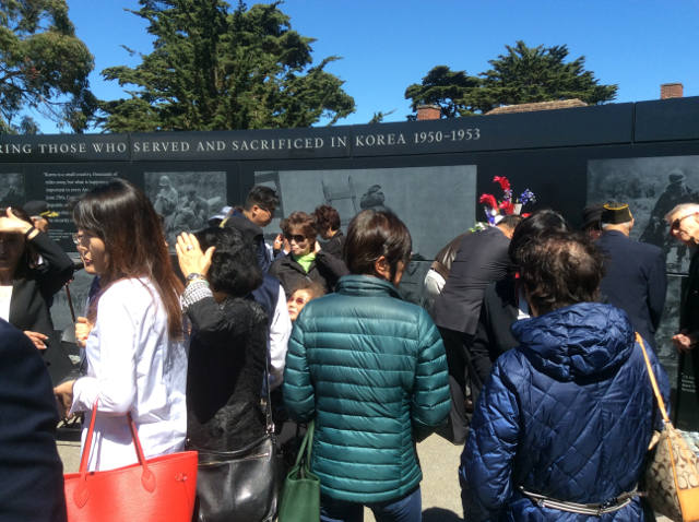 people gathering at the memorial wall