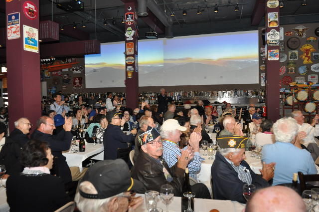 photo of large restaurant audience applauding performers